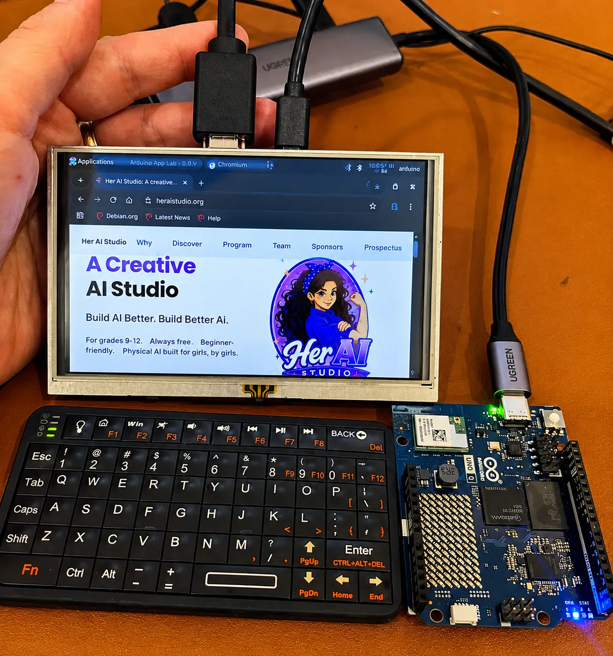 An AI kit prototype: a small touchscreen running a browser, a bluetooth keyboard, and an exposed Arduino board wired together with USB hub cables on a desk.